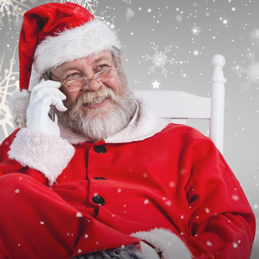 A picture of Santa Claus talking on a cell phone.